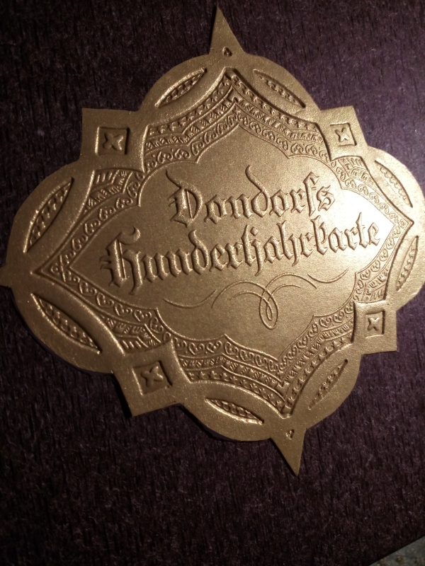 Details of the hand made dual tuck boxes with gold "buckle" logo / emblem